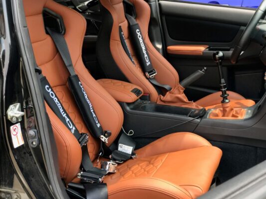 Orange and black custom leather seats in a sports car